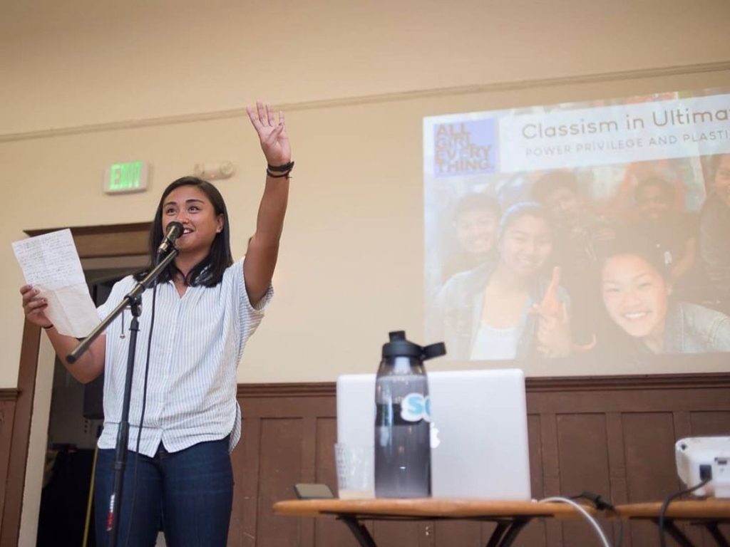 young woman speaking to the crowd and encouraging everyone to engage 