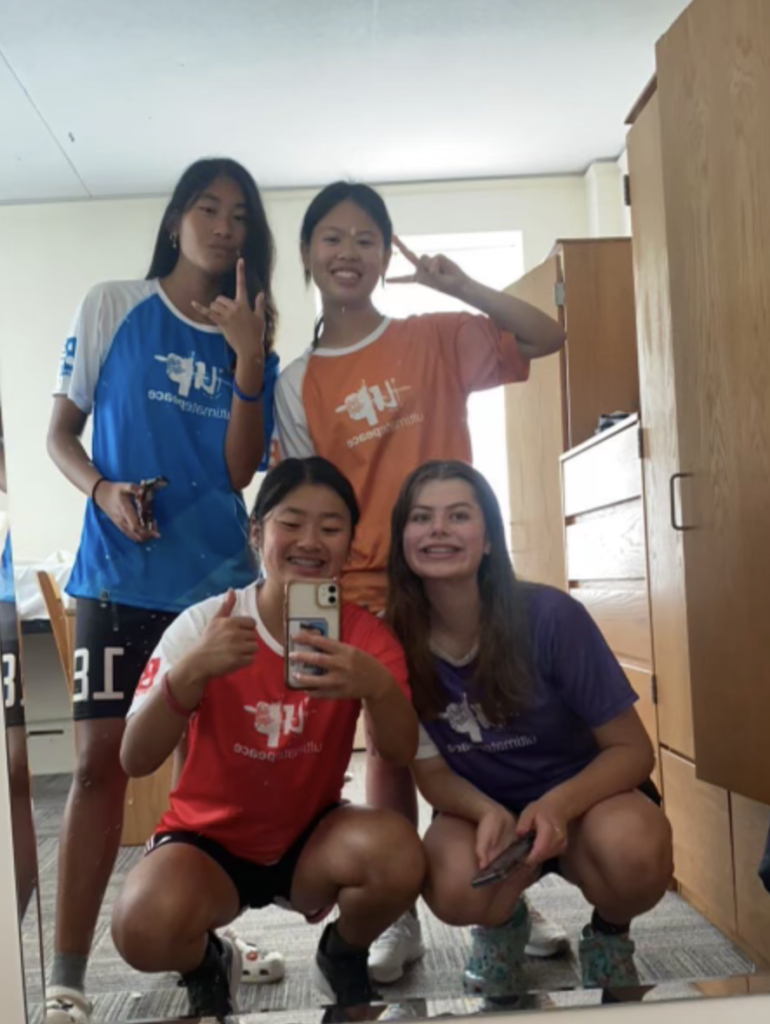 4 young girls in different colored jerseys pose for a pic in the mirror
