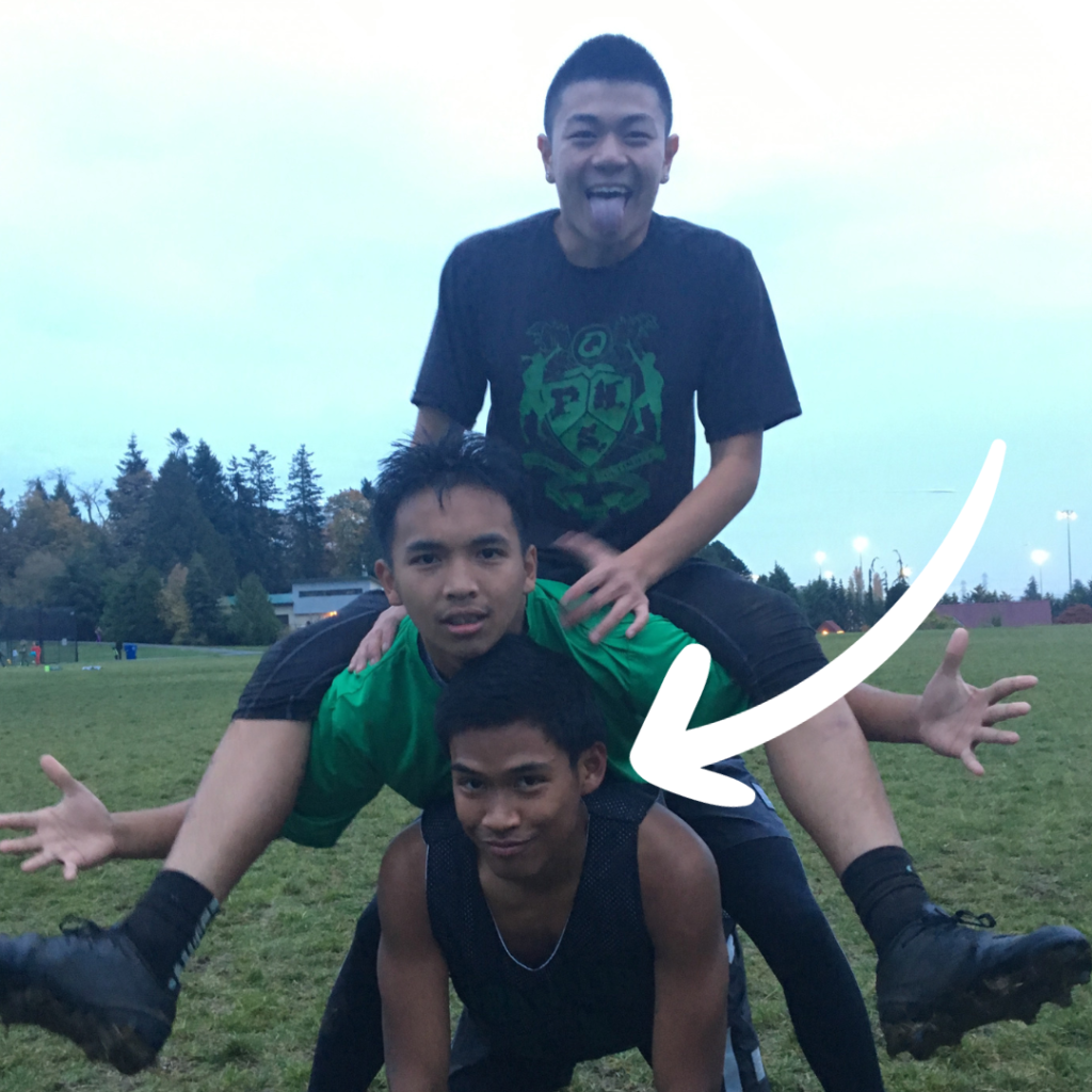 three young men climbing on top of each other at a tournament