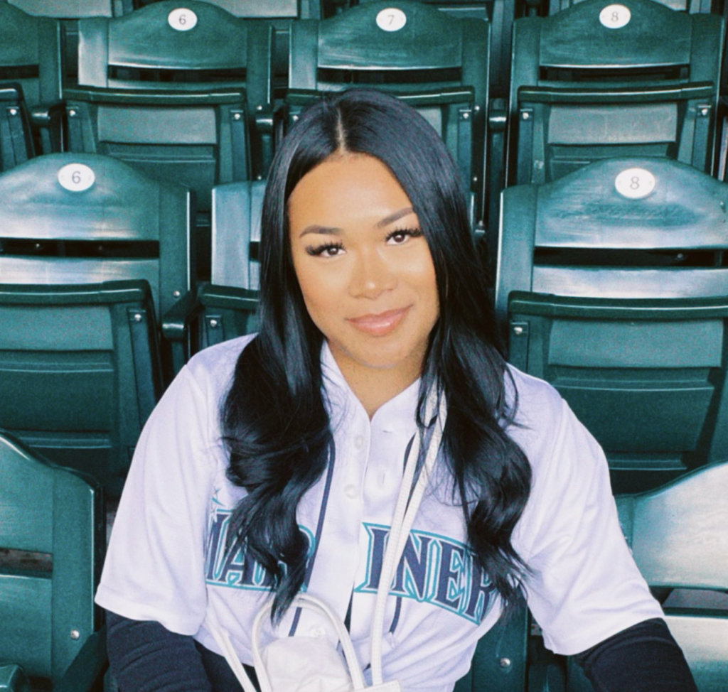 young woman with straight dark hair in a mariners jersey
