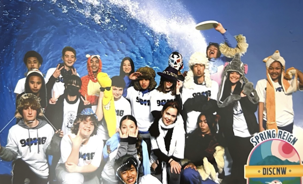 a group of kids pose in a photobooth at a frisbee tournament